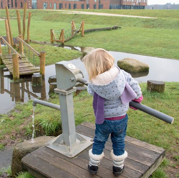 Meisje in waterspeeltuin met veel groen