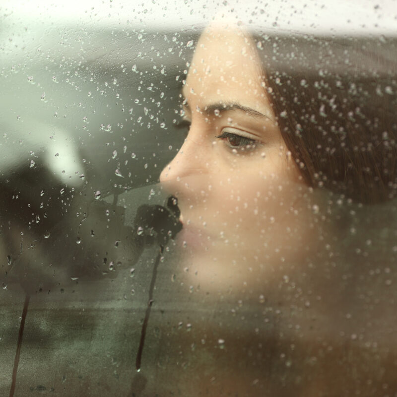 Mesije kijkt verdrietig vanachter een raam naar buiten.