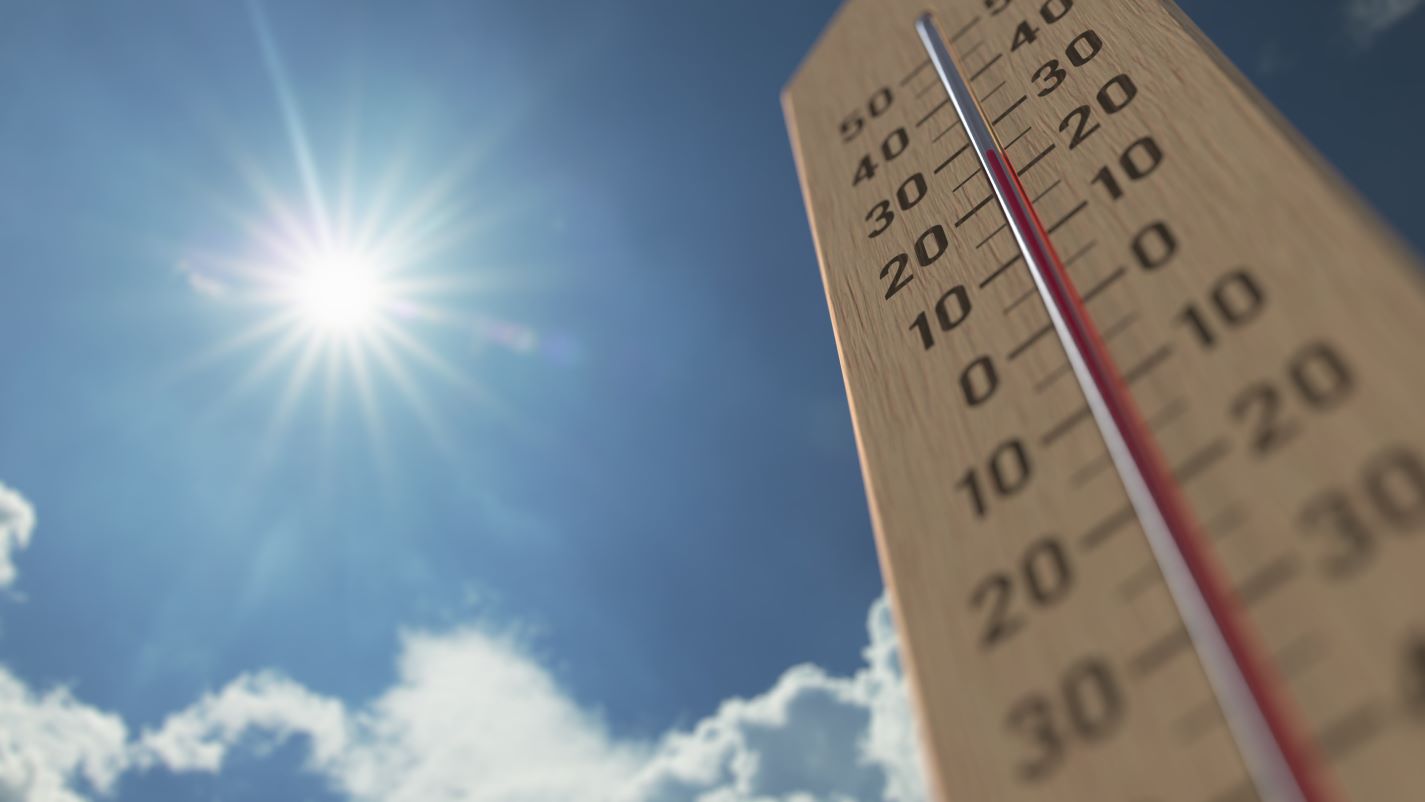 Thermometer tegen een blauwe lucht met felle zon wijst rond de 25 graden aan. De zomer is heerlijk maar brengt ook gezondheidsrisico's met zich mee.