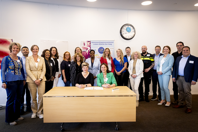 Vertegenvwoordigers van de betrokken partijen van de alliantie poseren tijdens de ondertekening van hun samenwerkingsovereenkomst.