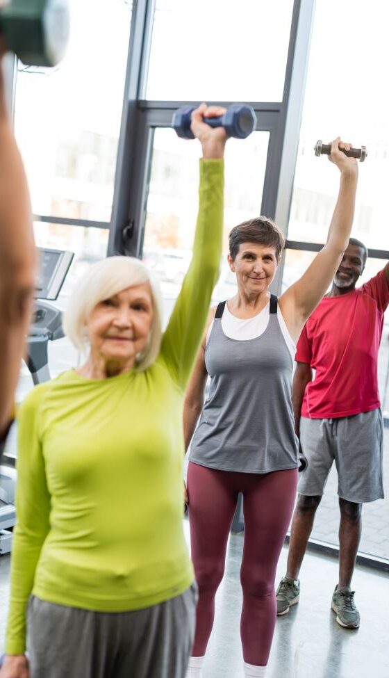 Oudere man en vrouwen aan het gymen