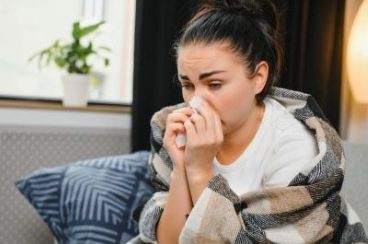 vrouw met griep snuit haar neus